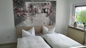 two beds in a room with a painting on the wall at Ferienhaus Bringfriede in Muldenhammer