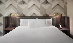 una camera da letto con un grande letto bianco con due lampade di Emory Conference Center Hotel ad Atlanta