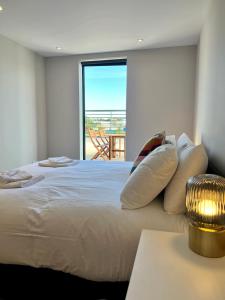 a bedroom with a bed with a view of a balcony at SoHot Stays Sea View Apartments in Kent