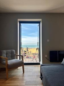 a bedroom with a chair and a view of the ocean at SoHot Stays Sea View Apartments in Kent