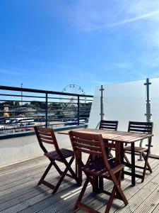 a wooden table and two chairs on a boardwalk at SoHot Stays Sea View Apartments in Kent