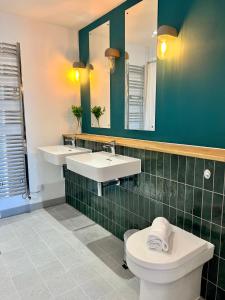 a bathroom with two sinks and a toilet and a mirror at SoHot Stays Sea View Apartments in Kent