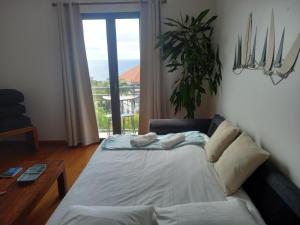 uma sala de estar com uma cama e uma janela em Amazing SEA LIGHT Apartment, close to the beach. em Santa Cruz - Madeira