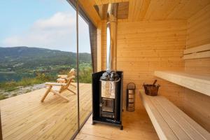a sauna with a fireplace on a wooden deck at Stamp and sauna! Small farm with fantastic view! in Favang