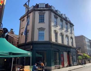 a building on a street with people sitting in front of it at Bristol Old City Studio in Bristol