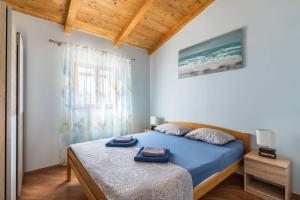 a bedroom with a bed with two towels on it at beautiful bay house Duga in Okrug Gornji