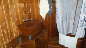 a wooden bathroom with a shower curtain and a table at Huma Terra Lodges in Hikkaduwa