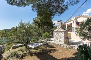 a house with a bench in front of a house at beautiful bay house Duga in Okrug Gornji