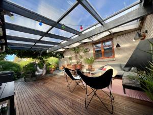 un patio con techo con sillas y mesa en Rosengren Residence, Fireplace & barbecue, en Billund