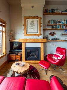 sala de estar con muebles de color rojo y chimenea en Bjørn Holm en Port Renfrew