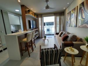 sala de estar con sofá y bar en Mariscal, 03 dormitórios, 80m do mar, com piscina, en Bombinhas
