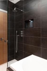 a bathroom with a shower with black tile at Fabulous Central Windsor Town House With Parking in Windsor