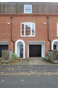 a brick building with three garage doors in front of it at Fabulous Central Windsor Town House With Parking in Windsor