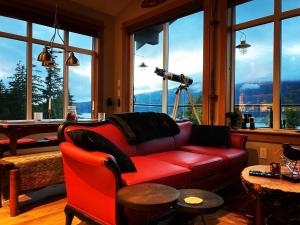 a living room with a red couch and a camera at Bjørn Holm in Port Renfrew