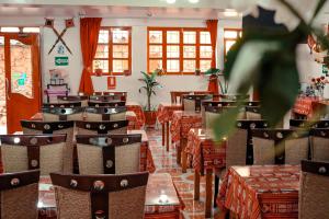 un restaurante con mesas y sillas en una habitación en Intitambo Hotel en Ollantaytambo