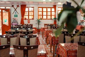 - un restaurant avec des tables et des chaises dans une salle dans l'établissement Intitambo Hotel, à Ollantaytambo