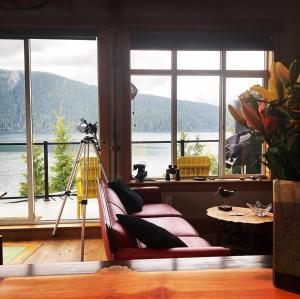a living room with a couch and a large window at Bjørn Holm in Port Renfrew