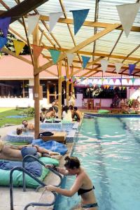 a group of people laying in a swimming pool at Mama Tungu hostel in Baños