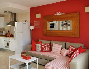 a living room with a couch and a red wall at My place in Cotillo 6 in El Cotillo