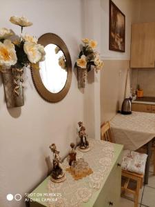 a kitchen with a table with flowers and a mirror at Evaggelia's Apartments 1 Διαμονή στο κέντρο in Kozani
