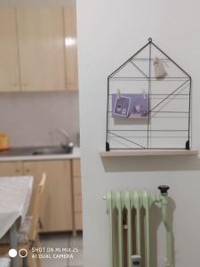 a shelf with a bird cage and a radiator in a kitchen at Evaggelia's Apartments 1 Διαμονή στο κέντρο in Kozani