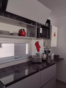 una cocina con encimera con cara roja en Departamento Caleta View en Puerto Madryn