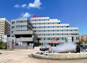 ein großes Gebäude mit einem Brunnen davor in der Unterkunft Ramada Iasi City Center in Iaşi