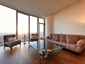 un soggiorno con divano e tavolo in vetro di A Luxury Residence 150m2, 3 min to Istinye Park Mall, 8 min to Vadi İstanbul, 2 Bedroom 3 Bathroom a Istanbul