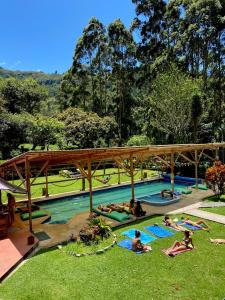 a group of people laying in the grass in a pool at Mama Tungu hostel in Baños