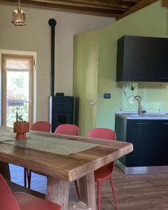 a kitchen with a wooden table and red chairs at Il Casias in Balme