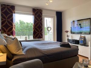 a bedroom with a large bed and a large window at Comfort-Apartment in Brilon