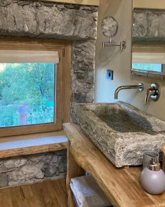 baño con lavabo de piedra y ventana en Il Casias en Balme