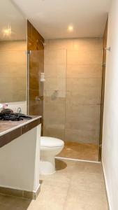 y baño con aseo y ducha acristalada. en Puerta Aqua by La Puerta Hostels, en Santa Marta