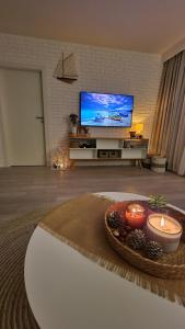 a living room with candles and a flat screen tv at Zielony Domek Apartament w Rewalu 42 m2, tylko 40 metrów od plaży in Rewal