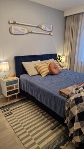 a bedroom with a blue bed with pillows on it at Zielony Domek Apartament w Rewalu 42 m2, tylko 40 metrów od plaży in Rewal