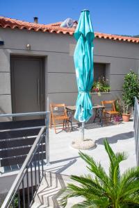 a patio with an umbrella and a table and chairs at Aelia in Agios Vlasios