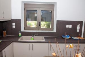 a kitchen with a sink and a window at Aelia in Agios Vlasios
