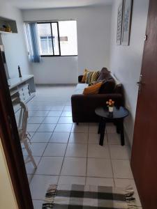 a living room with a couch and a table at Apartamento com piscina a uma quadra da praia de jatiuca in Maceió