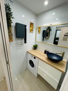 y baño con lavabo y lavadora. en Grand studio en centre ville et à 50 mètres du port, climatisé en La Grande-Motte