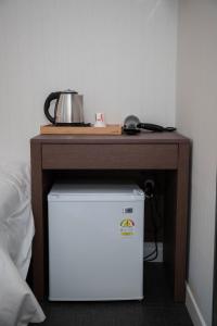 a table with a tea kettle on top of a refrigerator at Calistar Hotel in Seoul