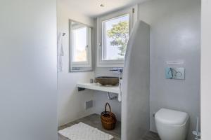 ein Badezimmer mit Toilette und Waschbecken und einem Fenster in der Unterkunft Villa Rose in Glossa + 138 Fotos