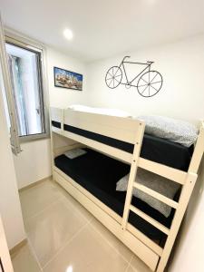 a bedroom with bunk beds with a bike on the wall at Grand studio en centre ville et à 50 mètres du port, climatisé in La Grande Motte
