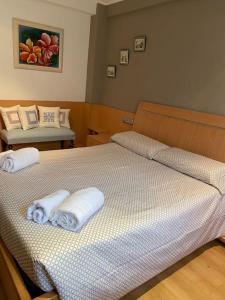 um quarto com 2 camas e toalhas em Rio Deba Gardens em San Sebastián