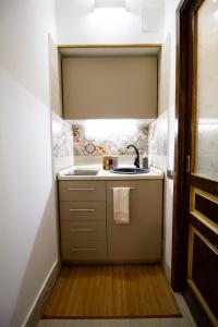 a small kitchen with a sink and a sink at Iris Ortigia Apartments in Syracuse