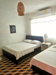 um quarto com 2 camas e uma janela em Casa el Muelle em Coveñas