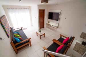 uma sala de estar com duas cadeiras e uma televisão em DUPLEX 2 SUÍTES CONDOMÍNIO MONT CARMELO em Porto Seguro
