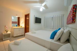 una camera da letto con un grande letto bianco e un bagno di DUPLEX 2 SUÍTES CONDOMÍNIO MONT CARMELO a Porto Seguro Altre 40 foto
