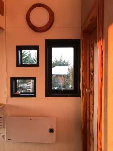 uma casa de banho com três janelas num quarto em Preciosa mini-casa-bote bien ubicada y linda vista em Buchupureo