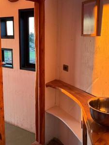 uma cozinha com um lavatório e um balcão com um lavatório em Preciosa mini-casa-bote bien ubicada y linda vista em Buchupureo