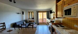 a kitchen and a living room with a couch at Appartement plein cœur de vallandry in Landry
